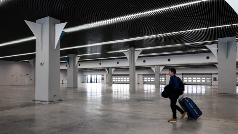 Traveler with luggage walking through a modern airport terminal
