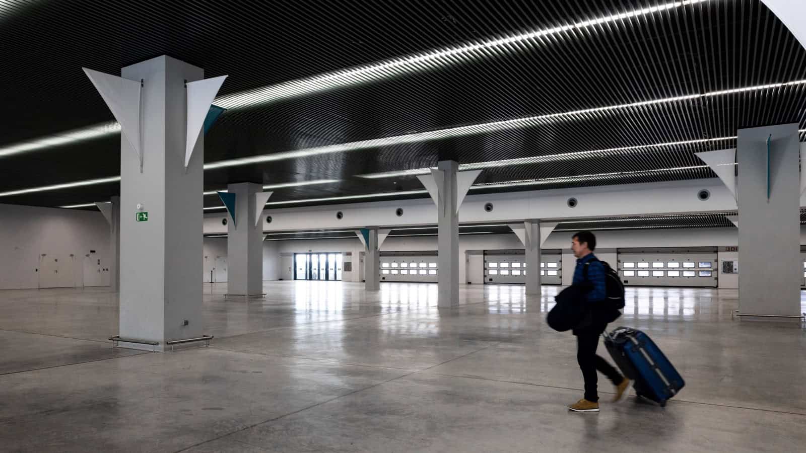 Traveler with luggage walking through a modern airport terminal